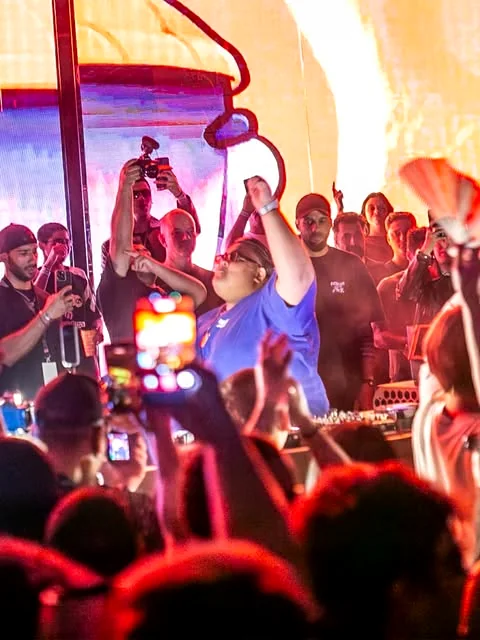 Pista do Vórtice cheia, com o DJ de braço erguido na cabine
